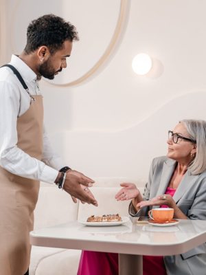 Waiter and Customer in a Hotel Restaurant Pointing a Dessert